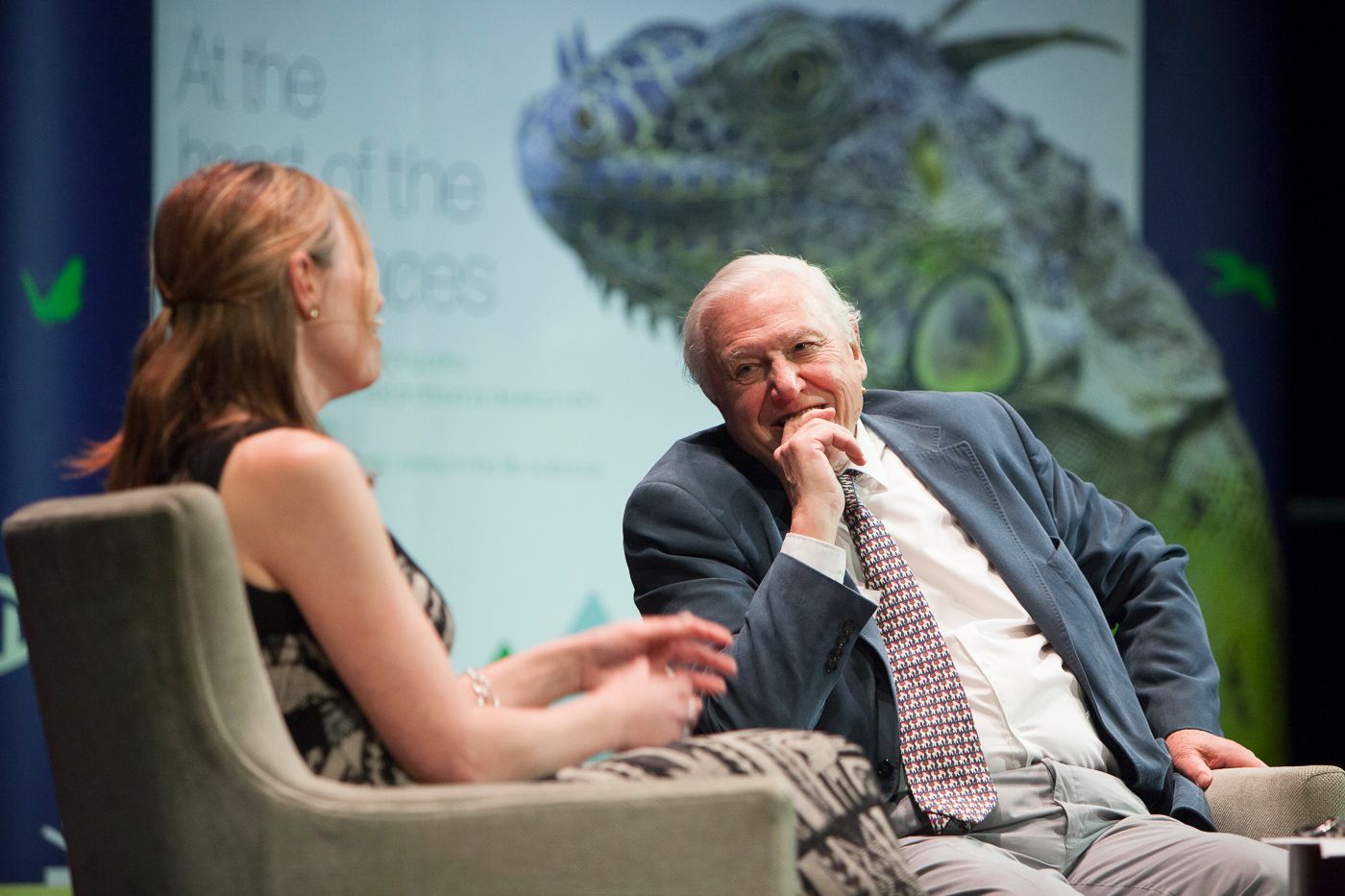 Sir David Attenborough sitting smiling during interview with Alice Roberts