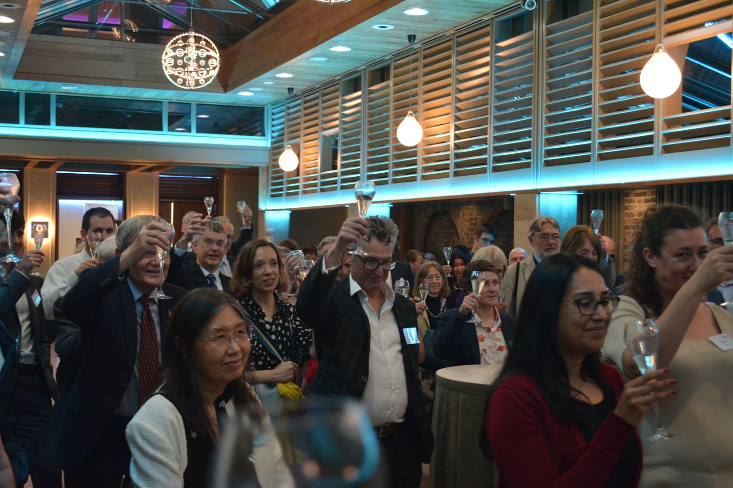 Crowd shot of guests raising their glasses