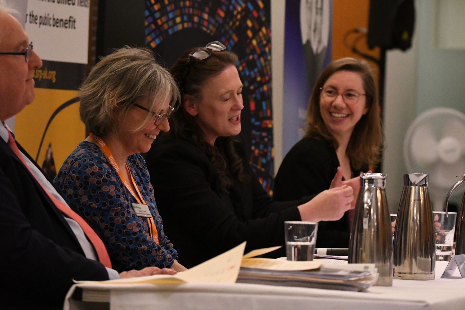 The Viscount Stansgate, Susie Rabin, Emily Darlington, and Lauren Sullivan sitting side by side on panel smiling and talking animatedly