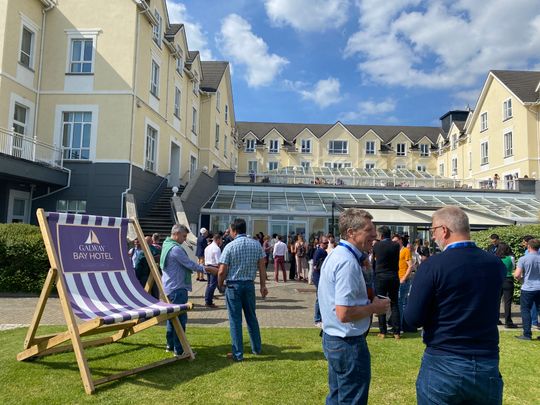 people networking outside a large building in the sunshine