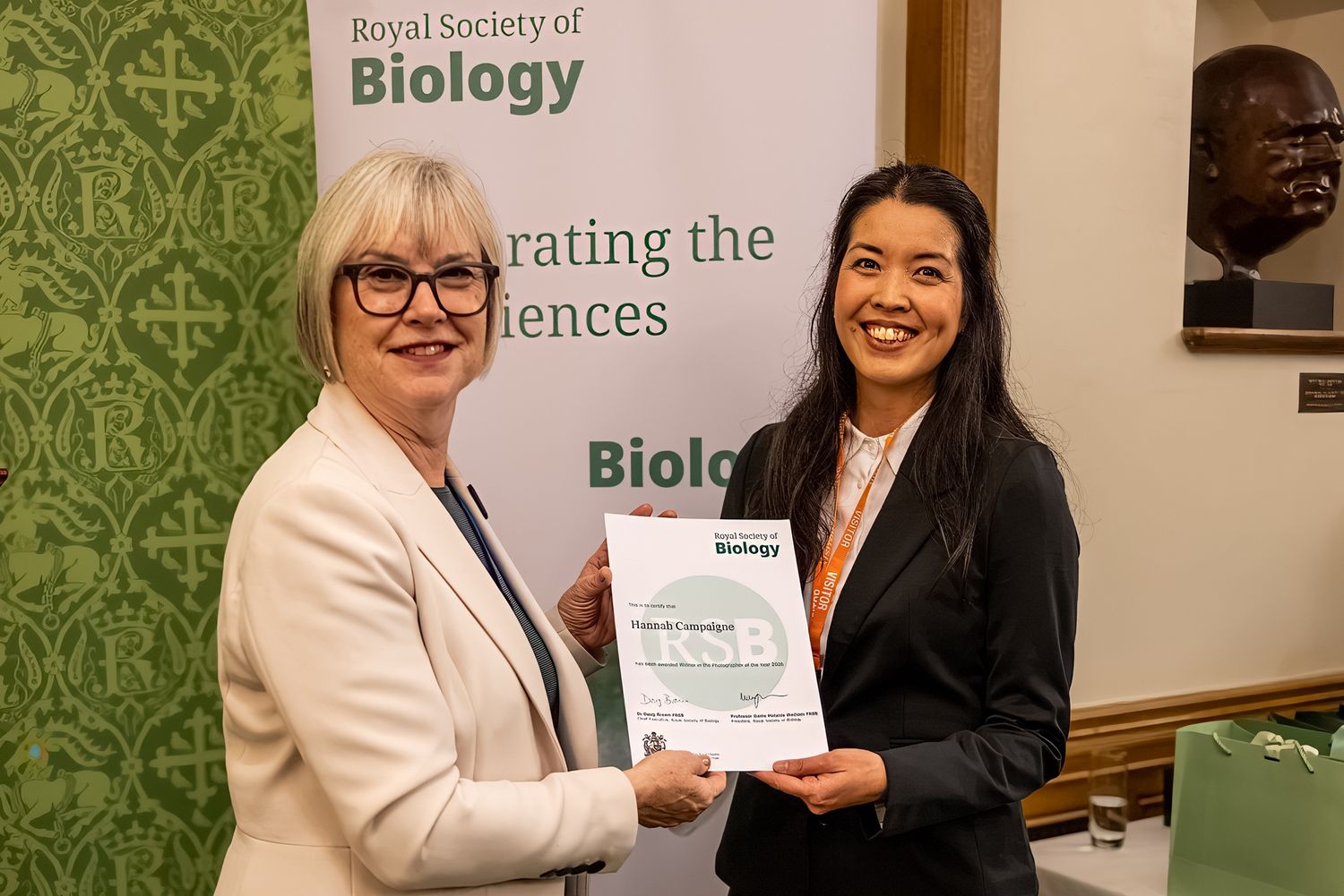 RSB President Professor Dame Melanie Welham and winner of the Photographer of the Year competition Hannah Campaigne, holding certificate in front of RSB banner