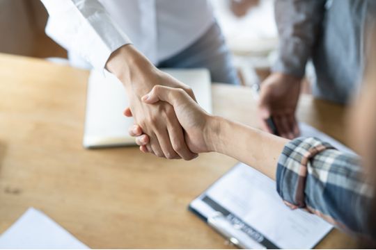 two hands shaking over a table